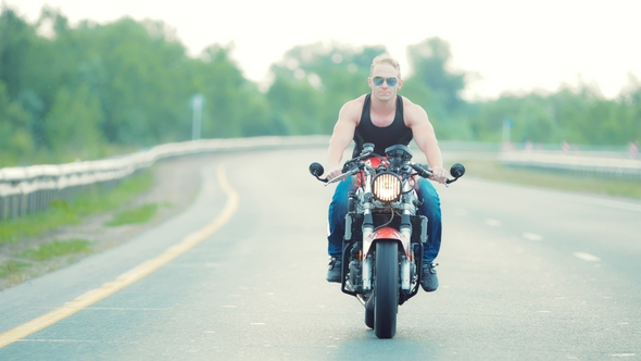 Motorcyclist Is Making a Large and Slow Turn To the Right on a Motorbike