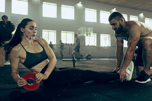 Fit young woman lifting barbells working out in a gym - Stock Photo - Images