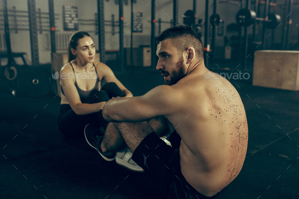 Man and woman during exercises in the fitness gym. CrossFit. - Stock Photo - Images