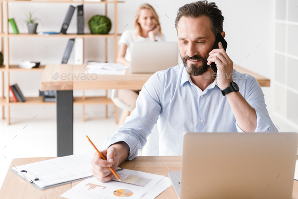 Smiling man manager working with laptop computer - Stock Photo - Images