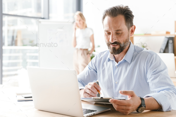 Confident man manager working on laptop computer - Stock Photo - Images