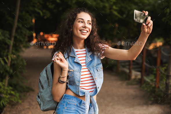 Photo of brunette pretty woman 18-20 with backpack, laughing and - Stock Photo - Images