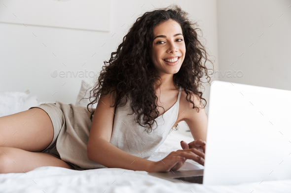 Photo of happy woman with long curly hair wearing silk leisure c - Stock Photo - Images