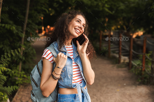 Photo of young brunette student 18-20 wearing backpack, smiling Stock Photo by vadymvdrobot