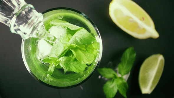 A Glass with Ice and Mint Pour Water