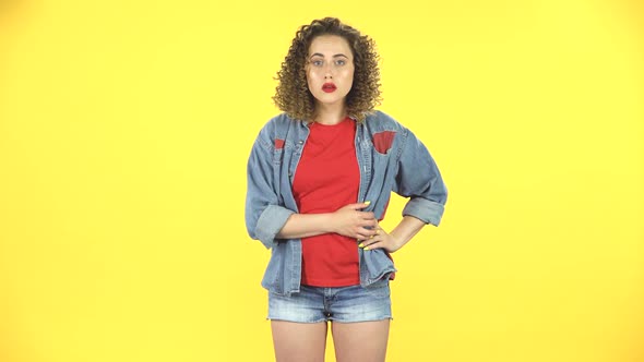 Girl Thinks and Listens, Looking Into the Camera with a Fork Forward, Shows the Index Finger alt