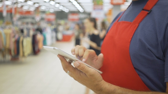 Salesperson Using a Digital Tablet in Supermarket