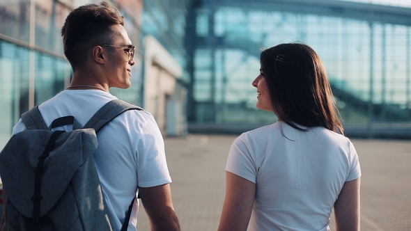 Happy Young Couple Goes with Luggage Near the Airport or Railway Station alt