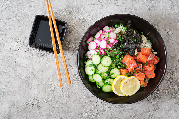 Hawaiian salmon fish poke bowl with rice, radish,cucumber, tomato, sesame seeds and seaweeds. - Stock Photo - Images