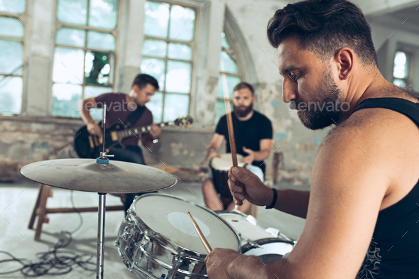 Repetition of rock music band. Electric guitar player and drummer behind the drum set. Stock Photo by master1305