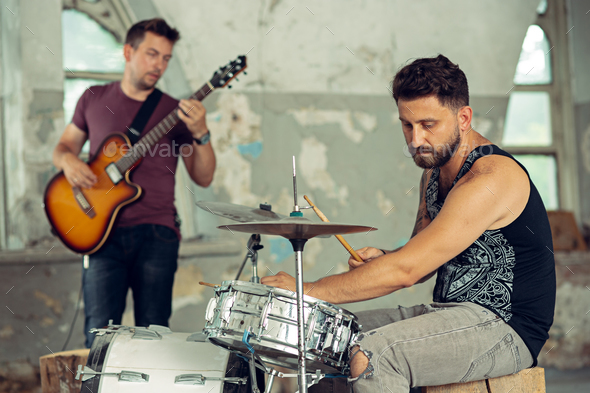 Repetition of rock music band. Electric guitar player and drummer behind the drum set. - Stock Photo - Images