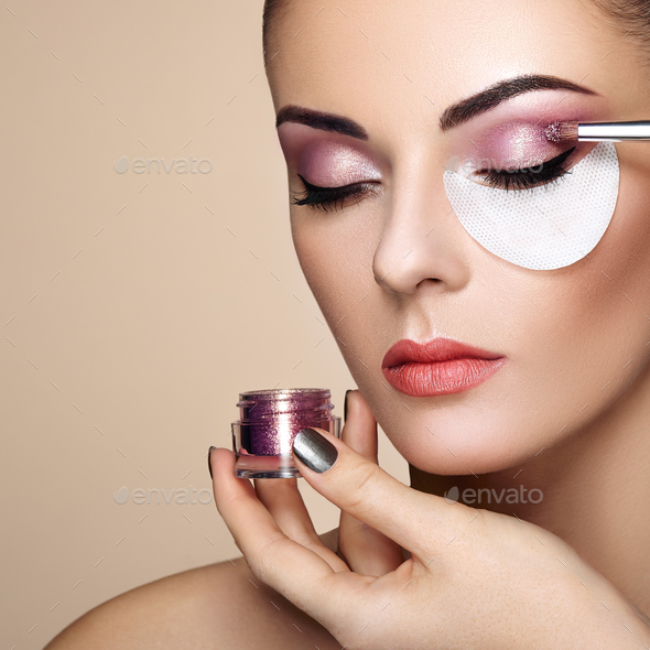 Makeup artist applies eye shadow - Stock Photo - Images