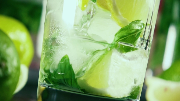Pour Vodka Into a Glass with Ice, Citrus and Mint