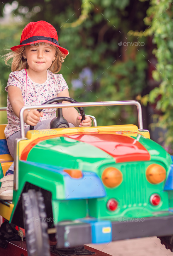 little girl driving toy car
