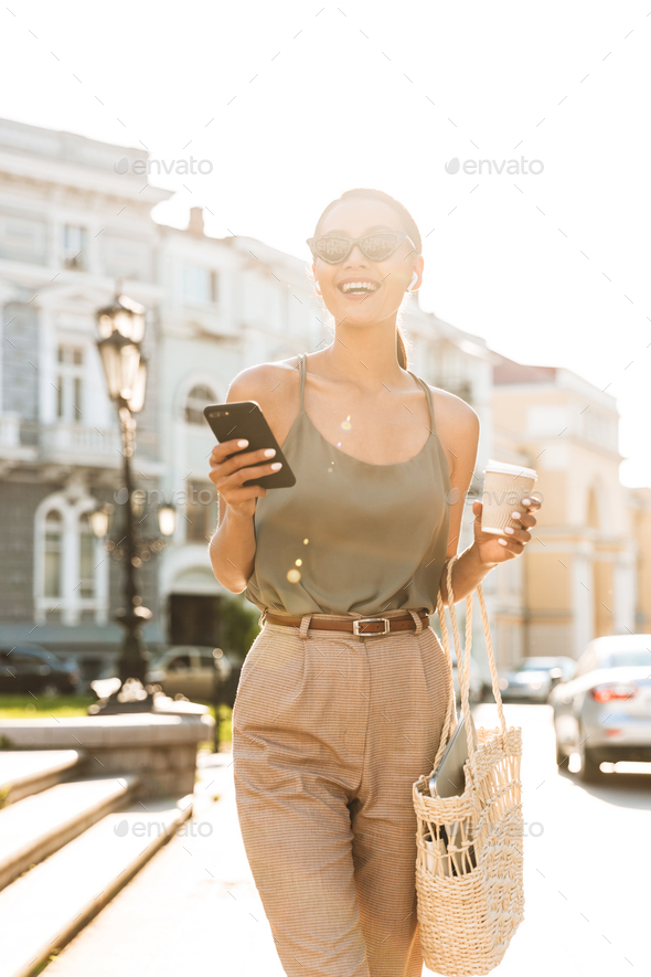 Portrait of smiling brunette woman wearing casual summer outfit, - Stock Photo - Images