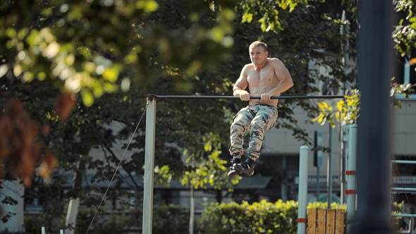 Young Athlete Makes a Pull-up on the Crossbar of the Output Power on the Sports Ground alt