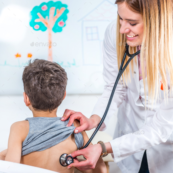 Pediatrician examining boy with stethoscope - Stock Photo - Images
