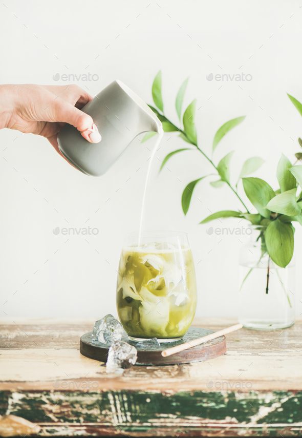 Iced matcha latte drink with coconut milk pouring from pitcher - Stock Photo - Images