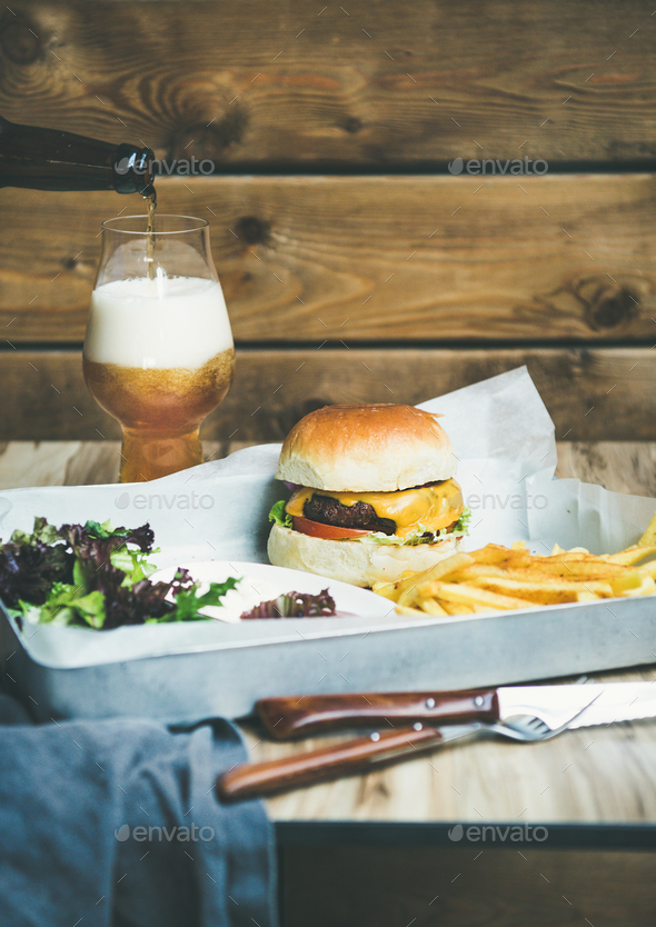 Beef burger, french fries, salad and glass of beer - Stock Photo - Images