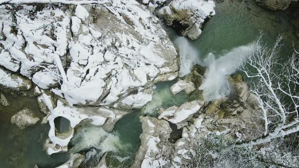 Waterfall Flowing From White Rocks Into a Lake in the Forest alt