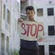 Portrait of Male Emigrant or Refugee Posing with Stop Banner at the Background of Neglected Urban - VideoHive Item for Sale