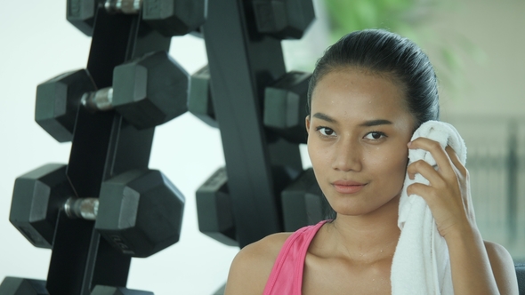 Portrait of Young Asian Female Athlete Wiping Sweat in Gym