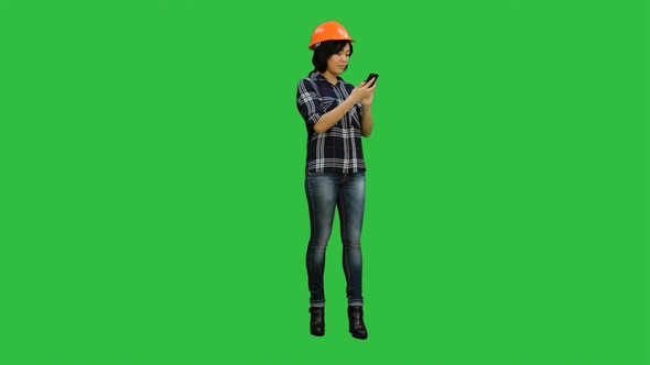 Young Asian Engineer Use Mobile Phone on a Green Screen, Chroma Key alt