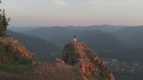 Young Happy Woman Standing on the Edge of a Cliff alt