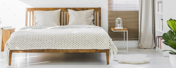 Front view of a simple wooden double bed with cushions and thick Stock Photo by bialasiewicz