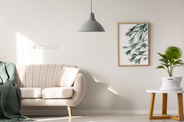 Real photo of a couch with blanket and pillow standing next to a - Stock Photo - Images