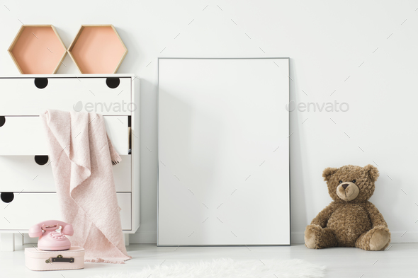 Teddy bear next to white empty poster in baby's room interior wi - Stock Photo - Images