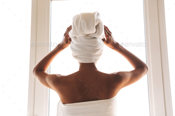 Back view of a young african woman wrapped in a towel Stock Photo by vadymvdrobot