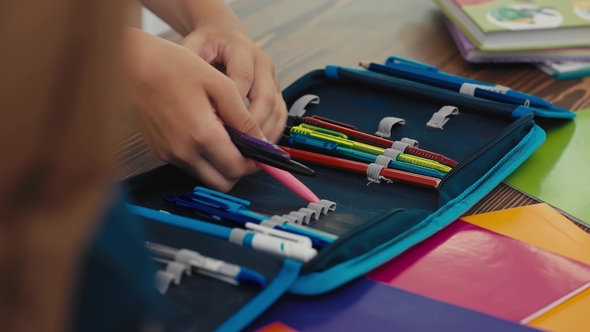 Student Puts Pens and Pencils in the Pencil Case