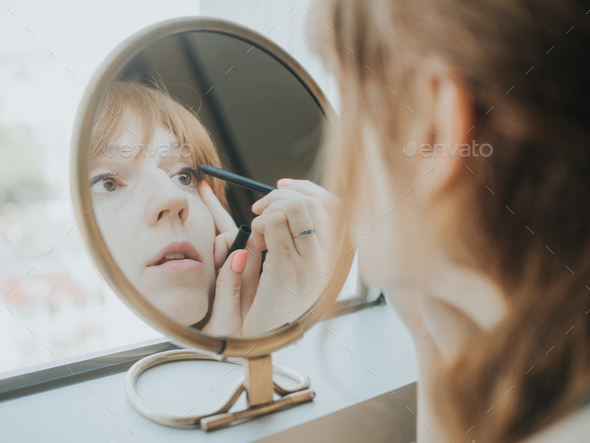 Woman Putting on Makeup in the Mirror Stock Photo by willmilne | PhotoDune
