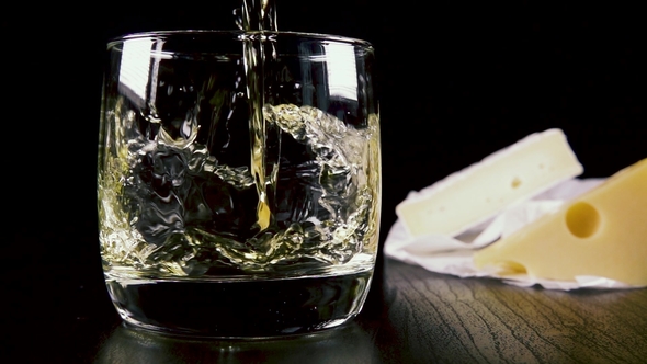 Strong Alcoholic Drink Pour Into a Glass Near the Snack