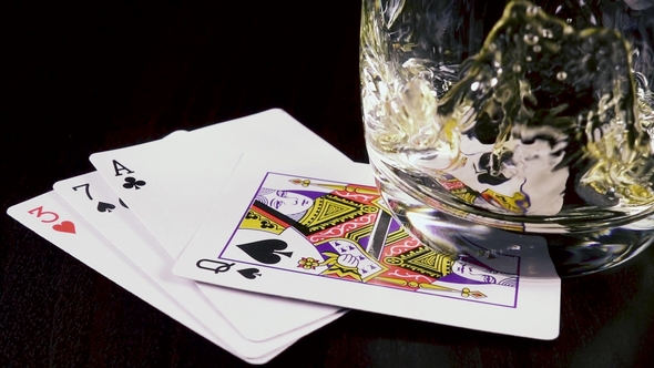 Strong Alcoholic Drink Pour Into a Glass and Playing Cards