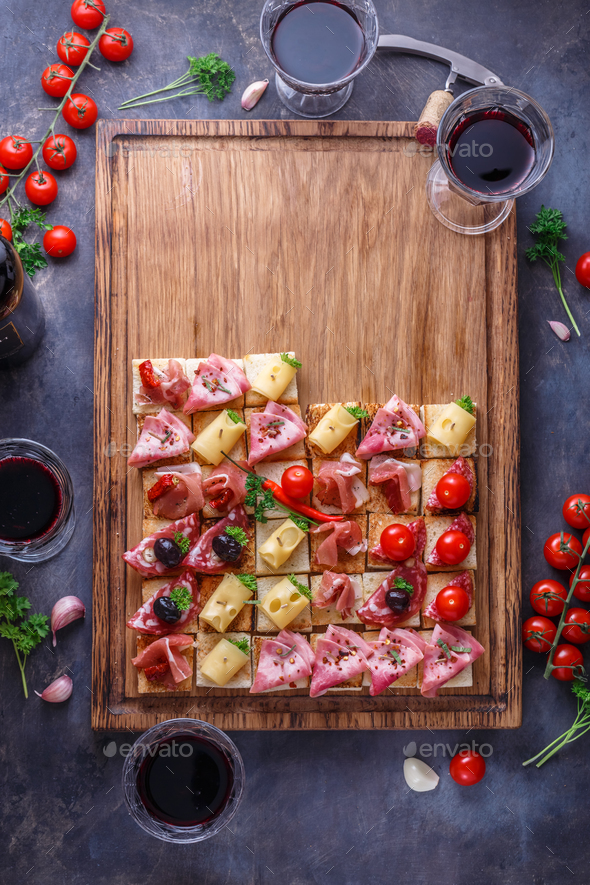 Tasty Italian appetizers, or bruschetta, slices of toasted baguette topped with ham, prosciutto - Stock Photo - Images