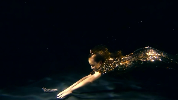 Little Mermaid Girl Is Floating Under Water and Taking From a Bottom a Brilliant Crown alt