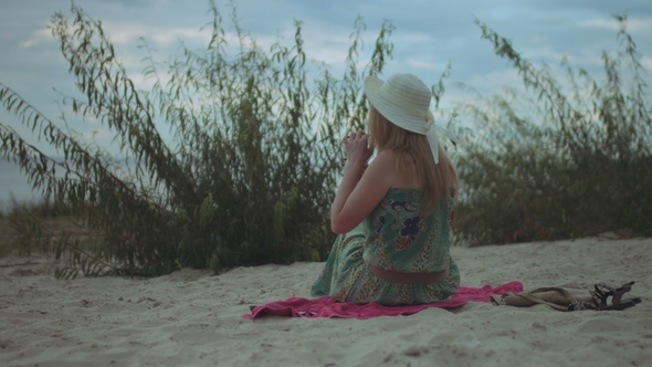 Relaxed Woman in Sunhat Enjoying Leisure on Beach alt