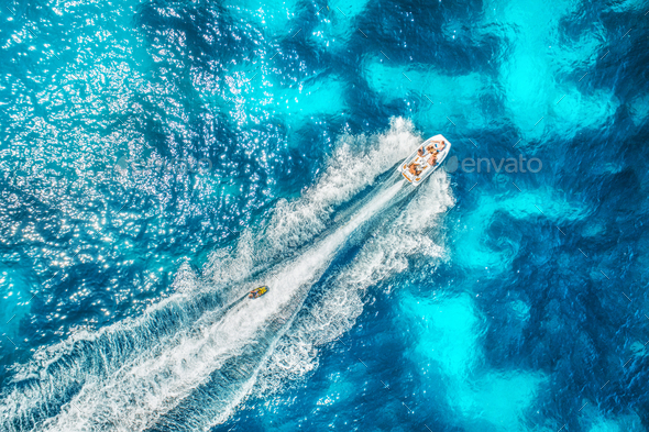 Aerial view of floating motorboat in transparent blue sea Stock Photo by den-belitsky