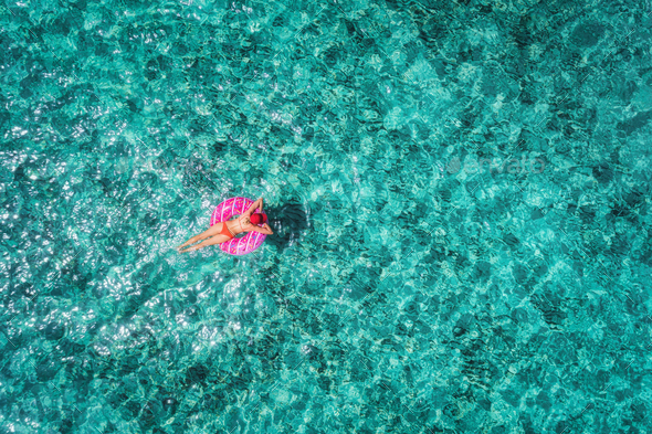 Aerial view of woman on the swim ring in the sea - Stock Photo - Images