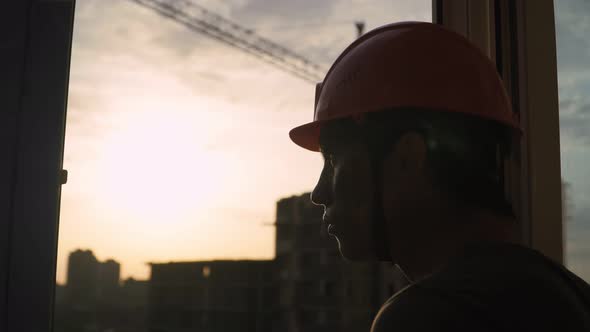 Silhouette Building Worker on Background Construction Crane and Sunset alt