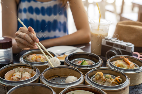 Young woman traveler eating local food(dim sum) at phuket, Thailand Stock Photo by kitzstocker