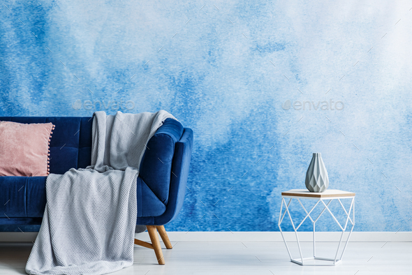 Contemporary openwork metal side table with vase next to a dark - Stock Photo - Images