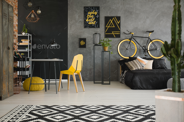 Black and yellow posters on concrete wall in spacious flat inter - Stock Photo - Images