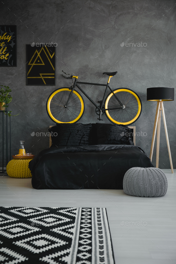 Bike above black bed in modern grey bedroom interior with patter Stock Photo by bialasiewicz
