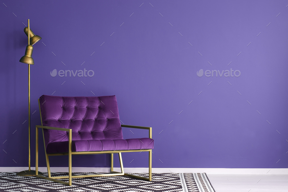 Ultra violet armchair with golden details and lamp standing on t Stock Photo by bialasiewicz