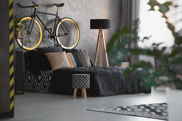 Small stool with black and white pattern standing next to the be - Stock Photo - Images