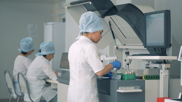 Female Lab Expert Is Putting Samples Into Clinical Chemistry Analyzer ...