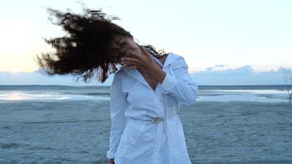 A Girl in a Beach Dress Dancing in Front of a Camera at Sunset